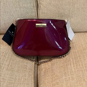 Kate Spade Burgundy Patent Clutch with an optional short chain.